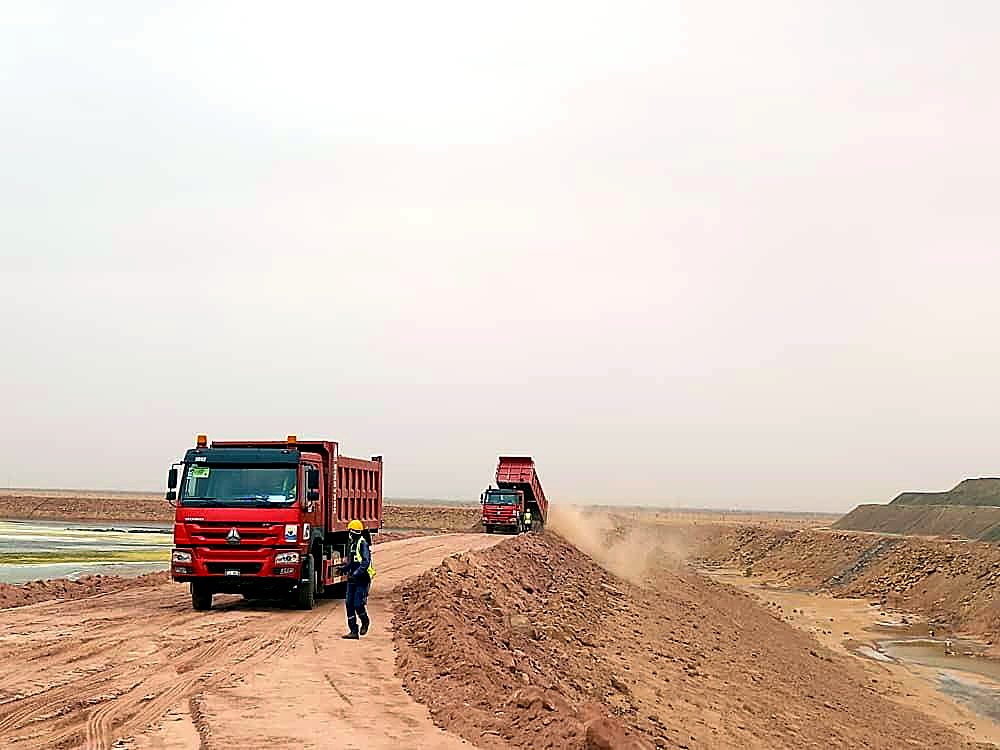 Camion benne EMHL déchargeant sur un remblai en construction