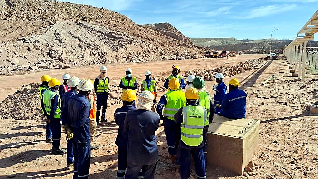 Briefing d'équipe EMHL en EPI, vue panoramique d'un chantier de terrassement