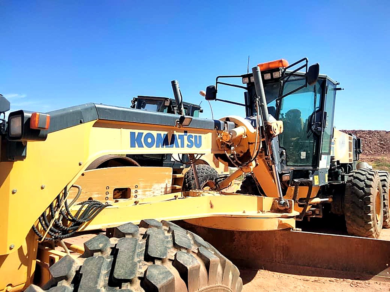 Niveleuse Komatsu GD705 du parc EMHL, vue trois-quarts imposante